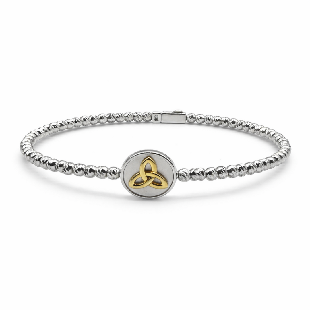 Silver bracelet with a gold Trinity knot charm on a white background