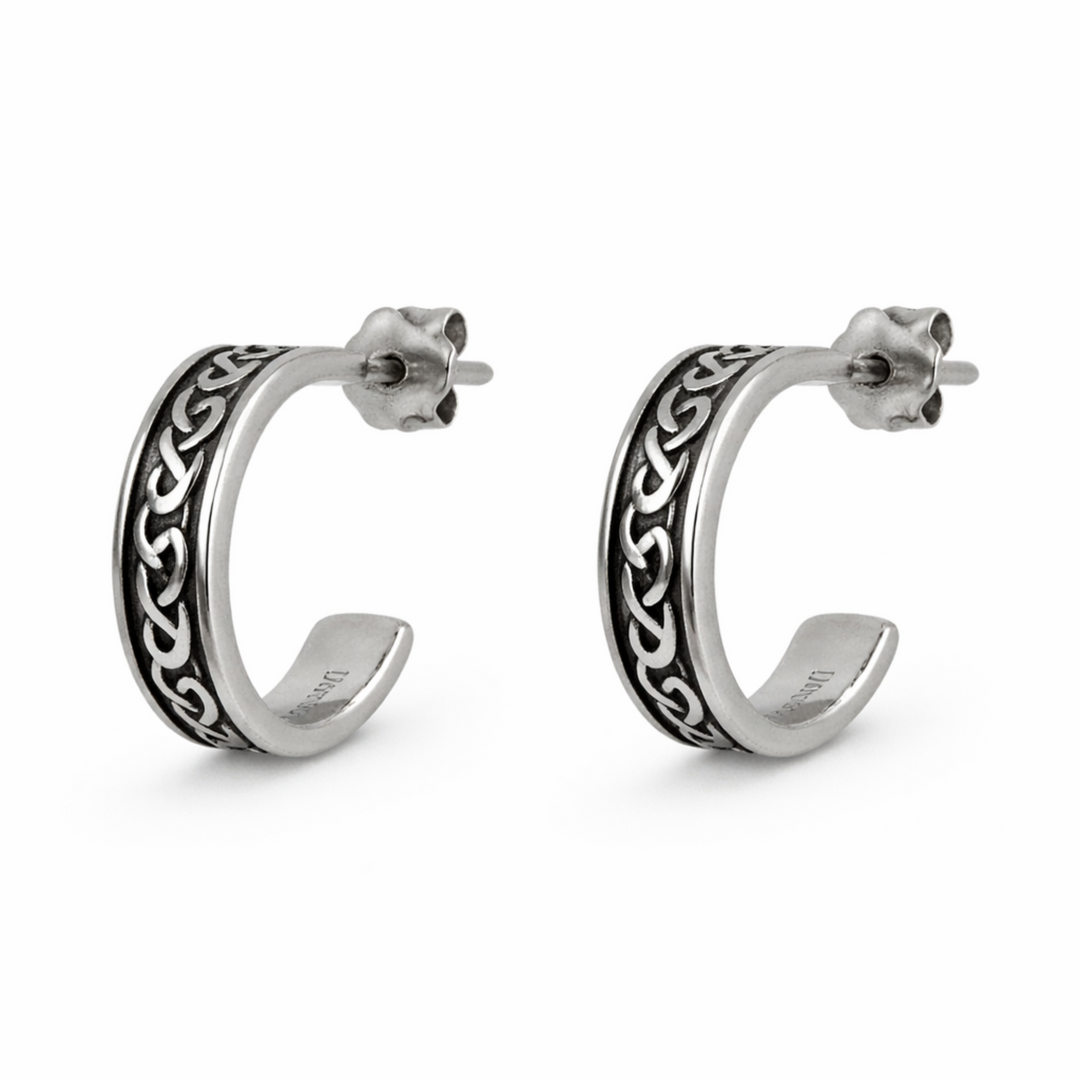 Pair of silver hoop earrings with intricate designs on a white background