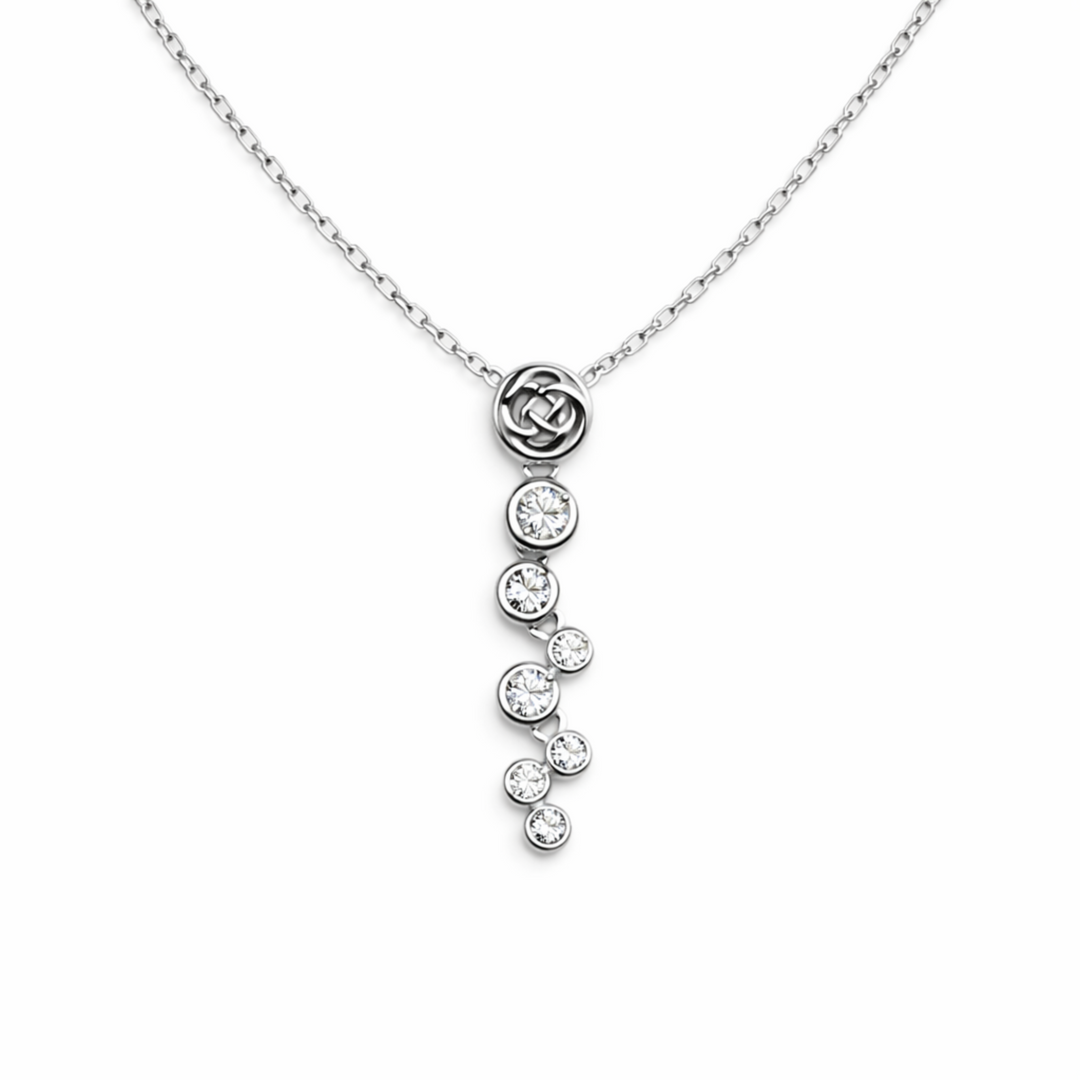 Silver necklace with a floral pendant and dangling crystals on a white background
