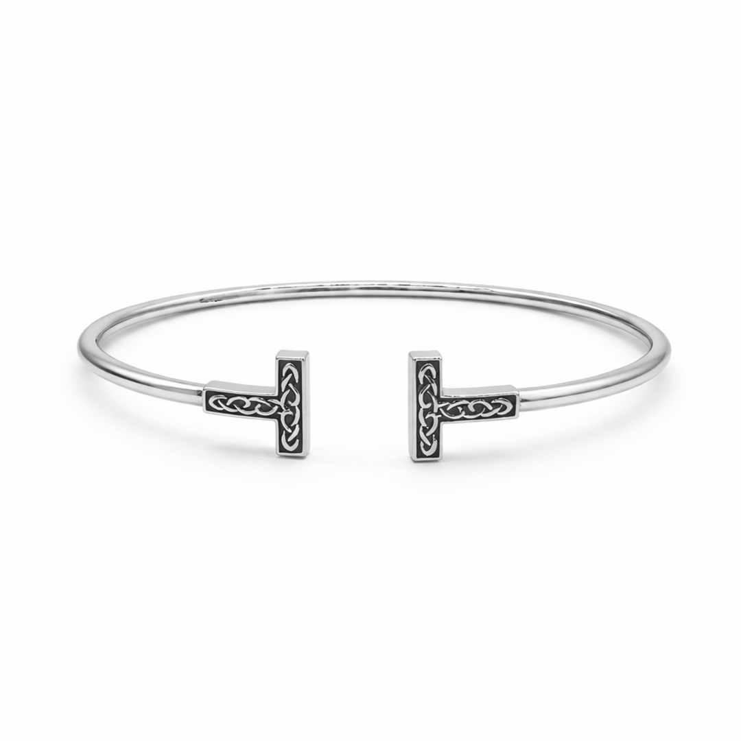 Silver bangle with Celtic knot designs on a white background