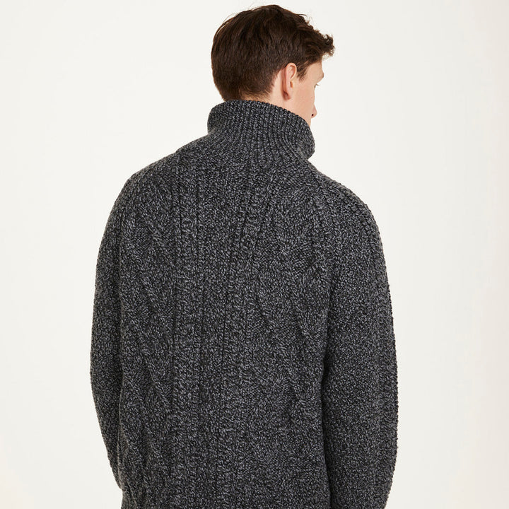 Man wearing a dark gray knitted sweater with a white background