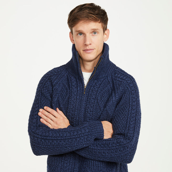 Man wearing a blue knitted sweater with a white background