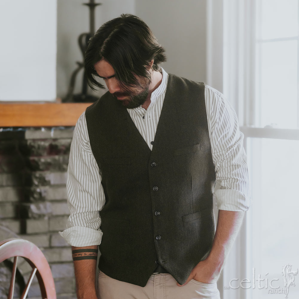 Man wearing a dark vest over a white shirt in an indoor setting