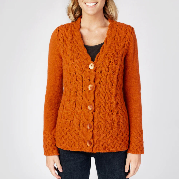 Orange cable knit cardigan worn by a person on a white background