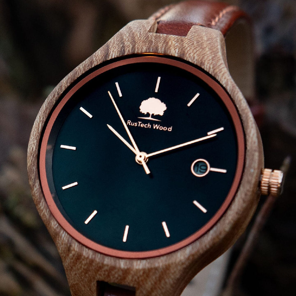 Wooden watch with a black face and brown leather strap on a blurred natural background